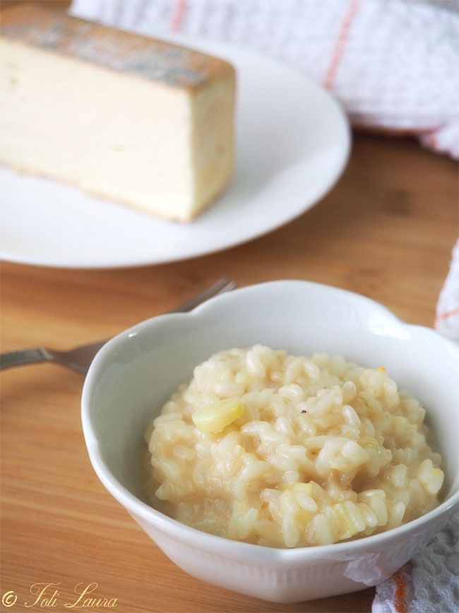 Risotto aux poireaux et au taleggio servi dans une assiette blanche