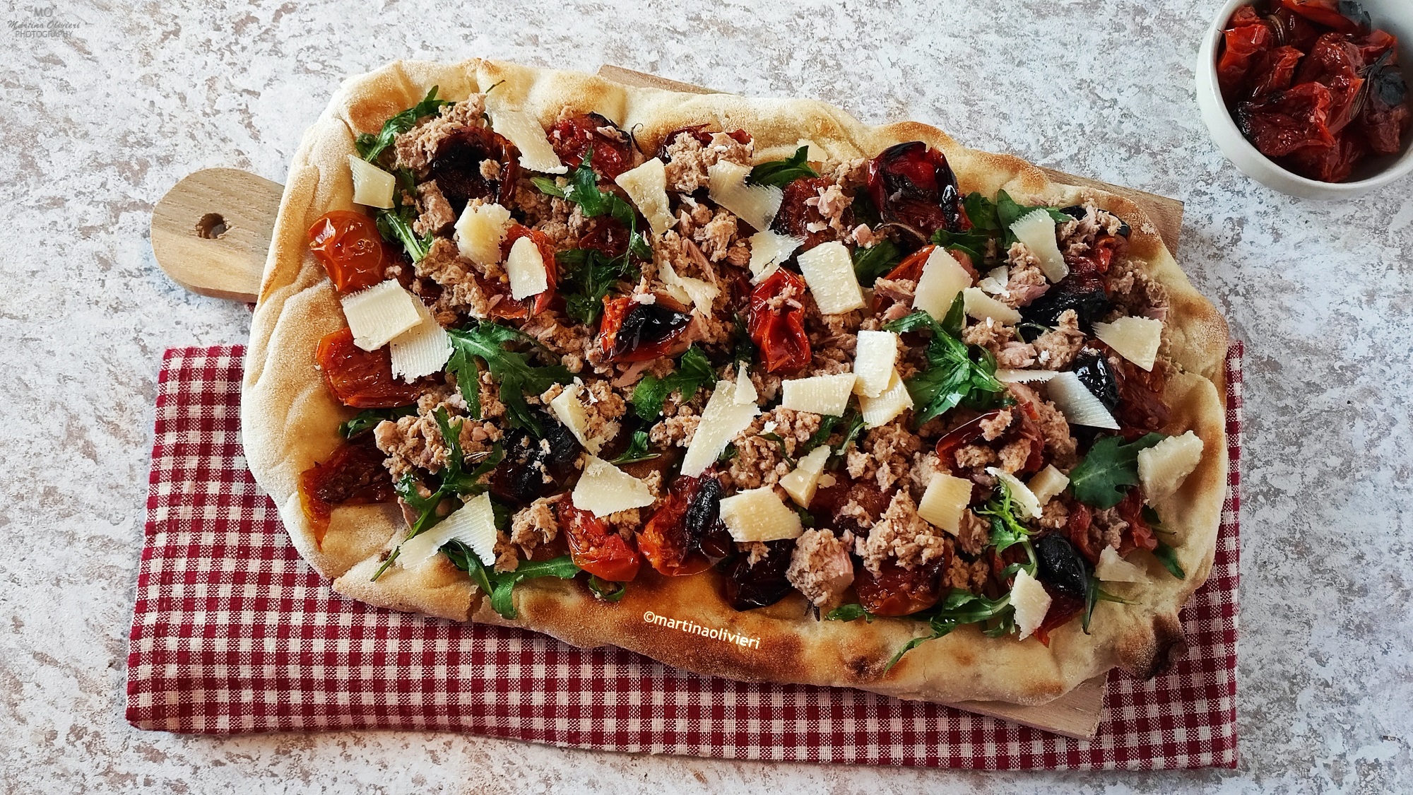 Pizza blanche avec thon, tomates cerises rôties et roquette