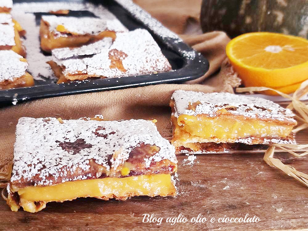 Feuilletés rapides avec crème de potiron et orange sur assiette, dorés et croustillants.