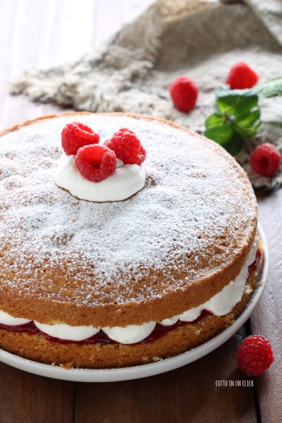 décorez le gâteau avec un petit tas de crème et des framboises fraîches