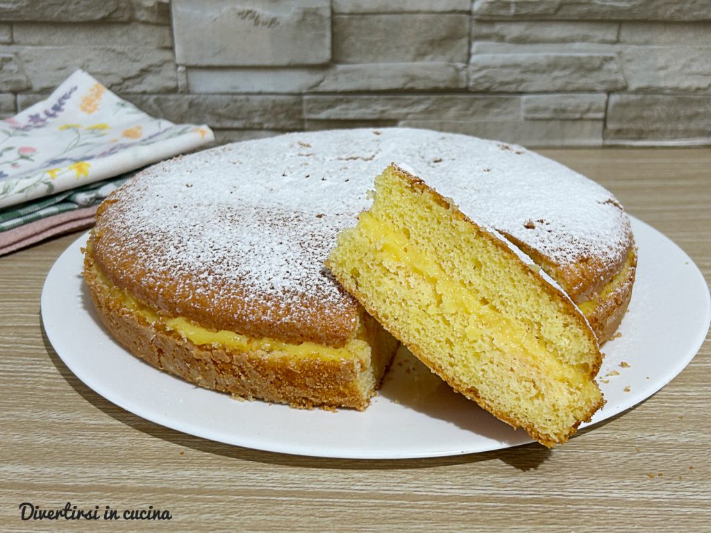Gâteau fourré à l'orange et au citron. Tranche coupée avec une couche de crème et décoration de sucre glace