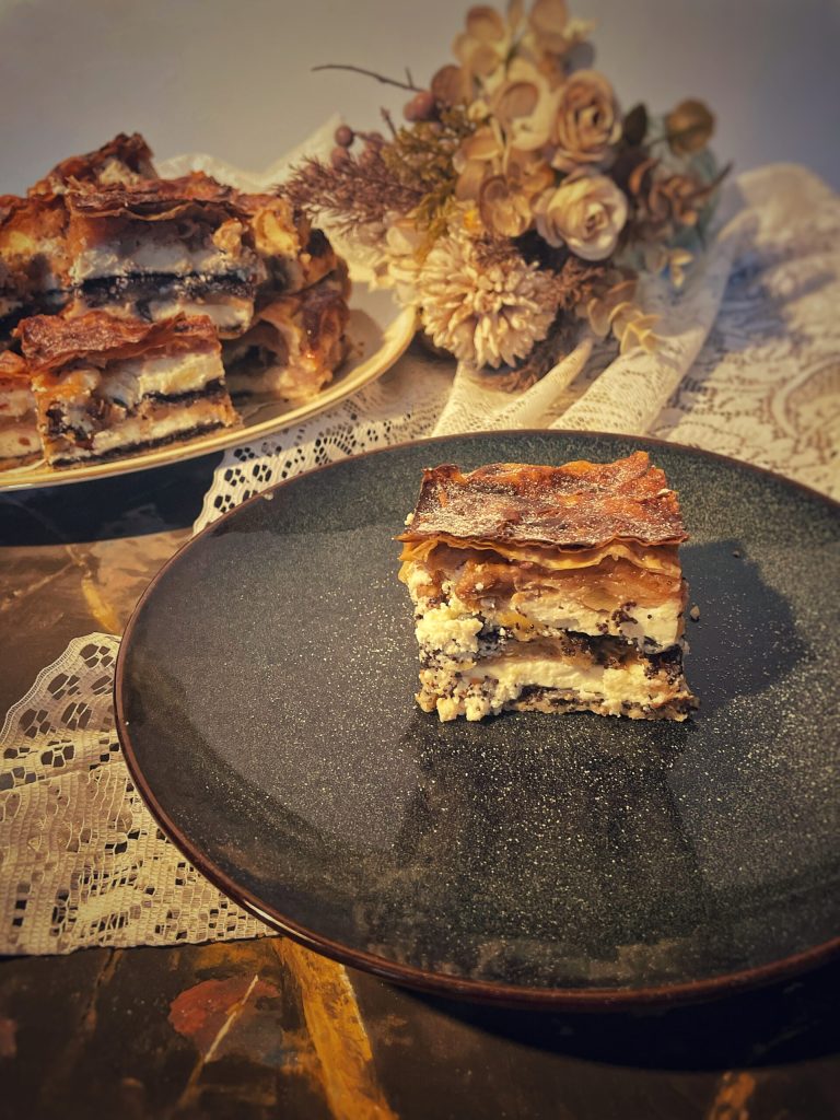 Tranche de Prekmurska Gibanica avec 8 couches visibles de graines de pavot, ricotta, noix et pommes