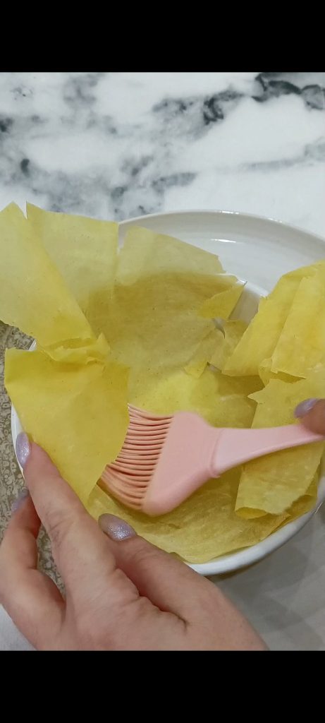 Nous plaçons une feuille de filo au fond d'un plat allant au four et nous badigeonnons