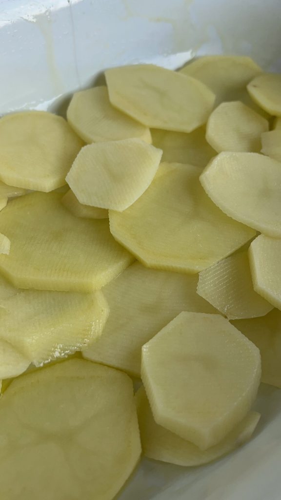 première couche de pommes de terre dans le plat pour cuisson au four