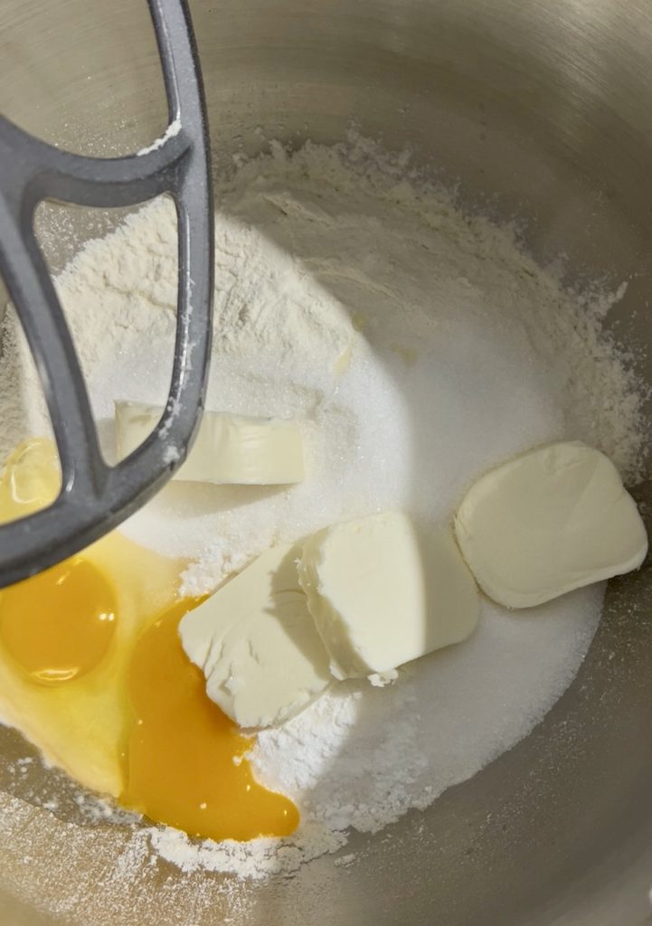 ingrédients de la pâte sablée dans le robot : beurre, œufs et farine