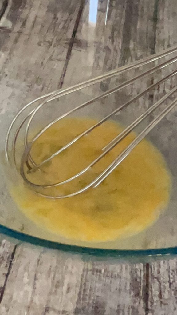œuf et sucre mélangés au fouet dans un bol pour pancakes aux fraises