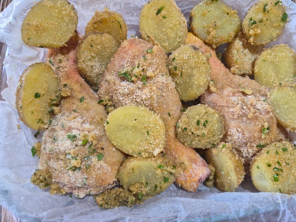 Cuisses et pilons de poulet gratinés avec pommes de terre croustillantes à la friteuse à air ou au four. Con pochi euro di pollo, due patate e del pangrattato, porti in tavola una cena completa per tutta la famiglia.
