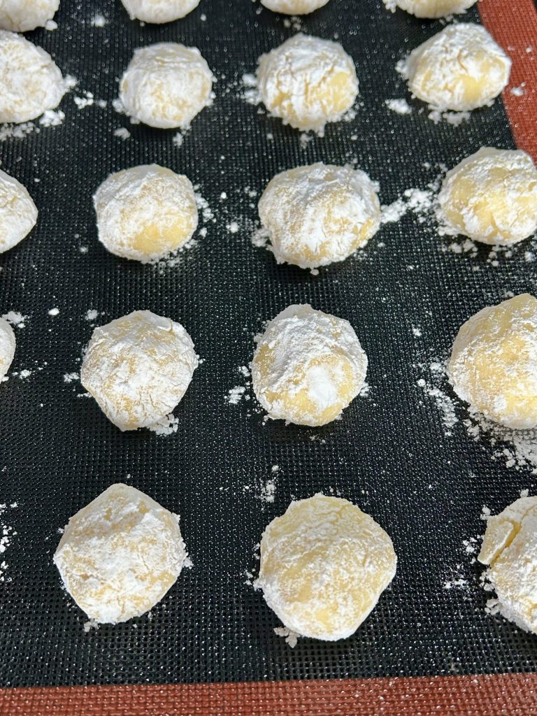 Boulettes de biscuits moelleux à l'orange recouvertes de sucre glace avant cuisson