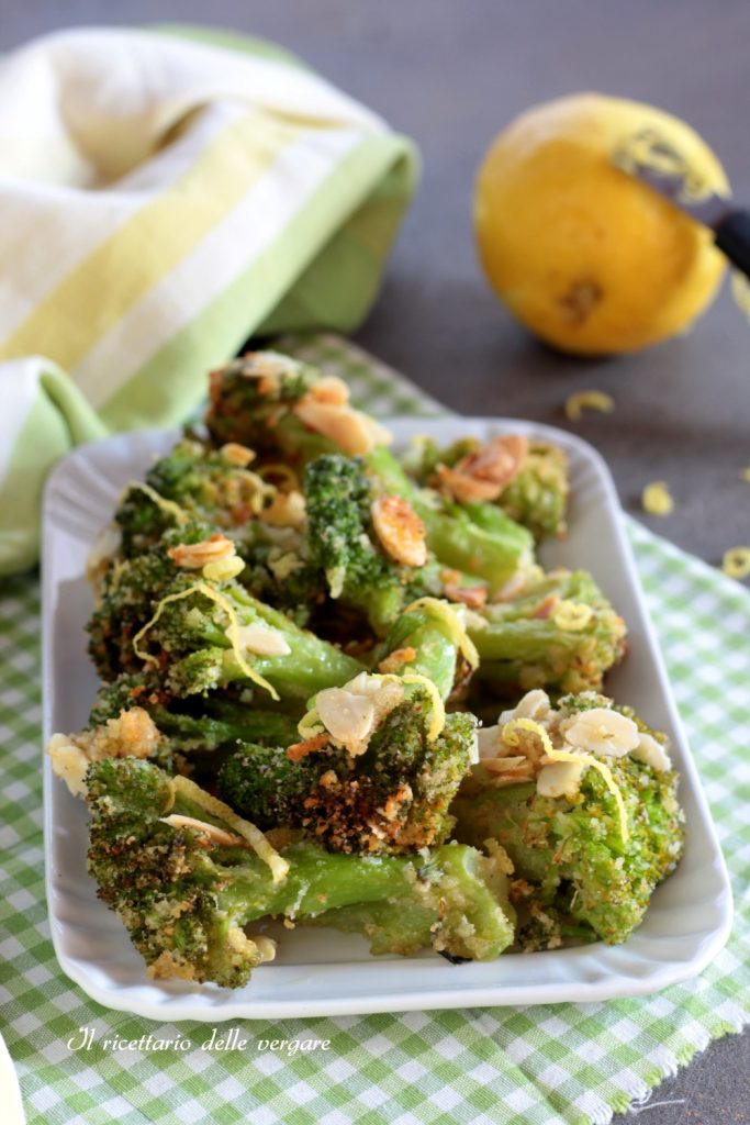 Assiette de brocolis gratinés avec amandes effilées et citron en arrière-plan, prêts à servir