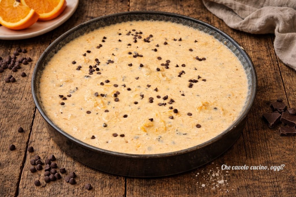 Pâte du gâteau à l'orange crue avec pépites de chocolat dans le moule, prête à être cuite