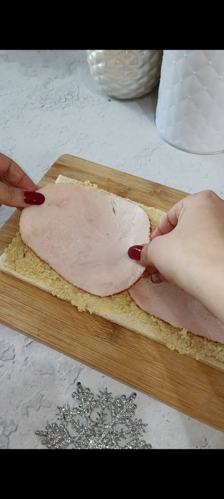 Rellenamos una rebanada de pan con paté de alcachofas y pechuga de pavo