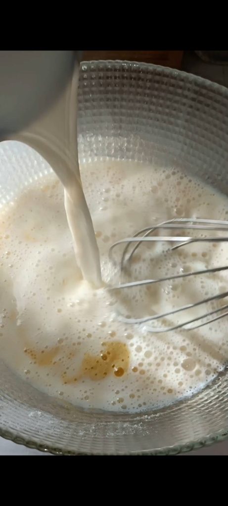 Vertemos la leche caliente sobre la mezcla de huevos