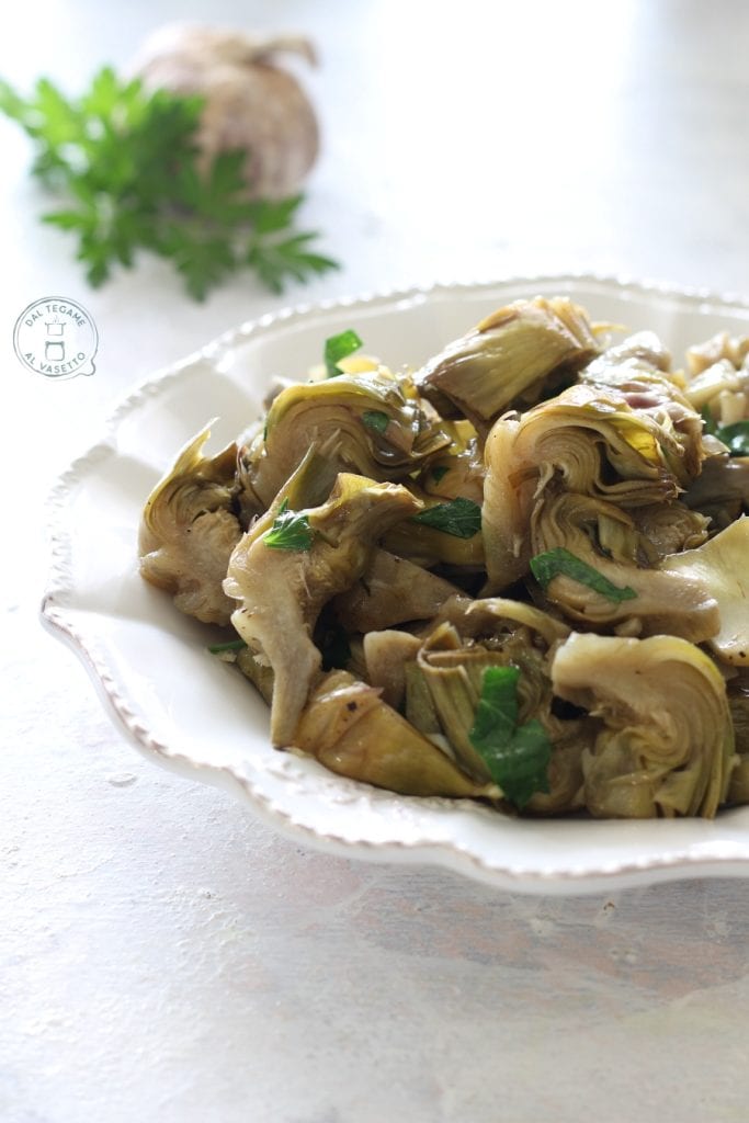 Plato de rodajas de alcachofas cocidas al microondas con ajo y perejil