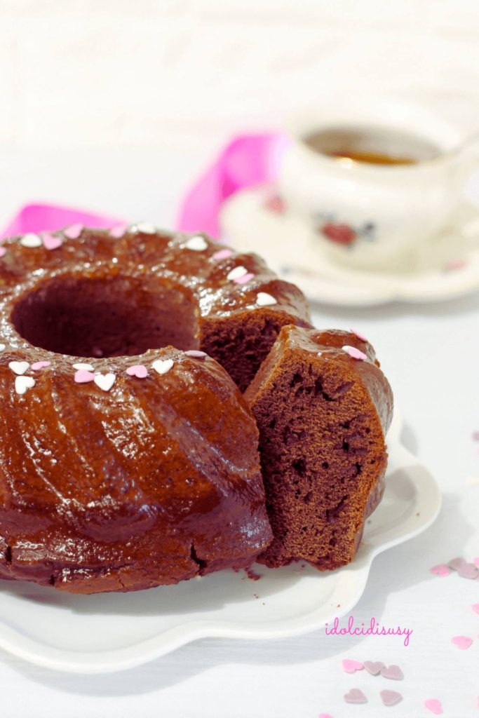Rodaja de bizcocho de cacao esponjoso y delicioso con glaseado brillante y azucarillos en forma de corazón