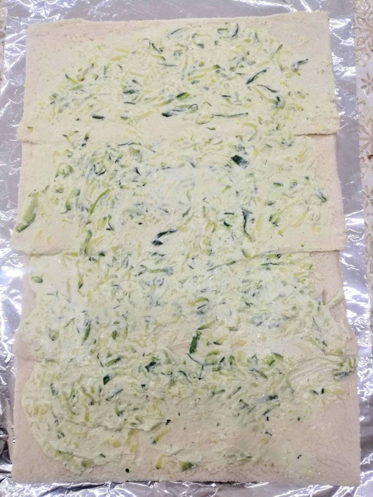 Crema de queso y calabacines extendida sobre las rebanadas de pan