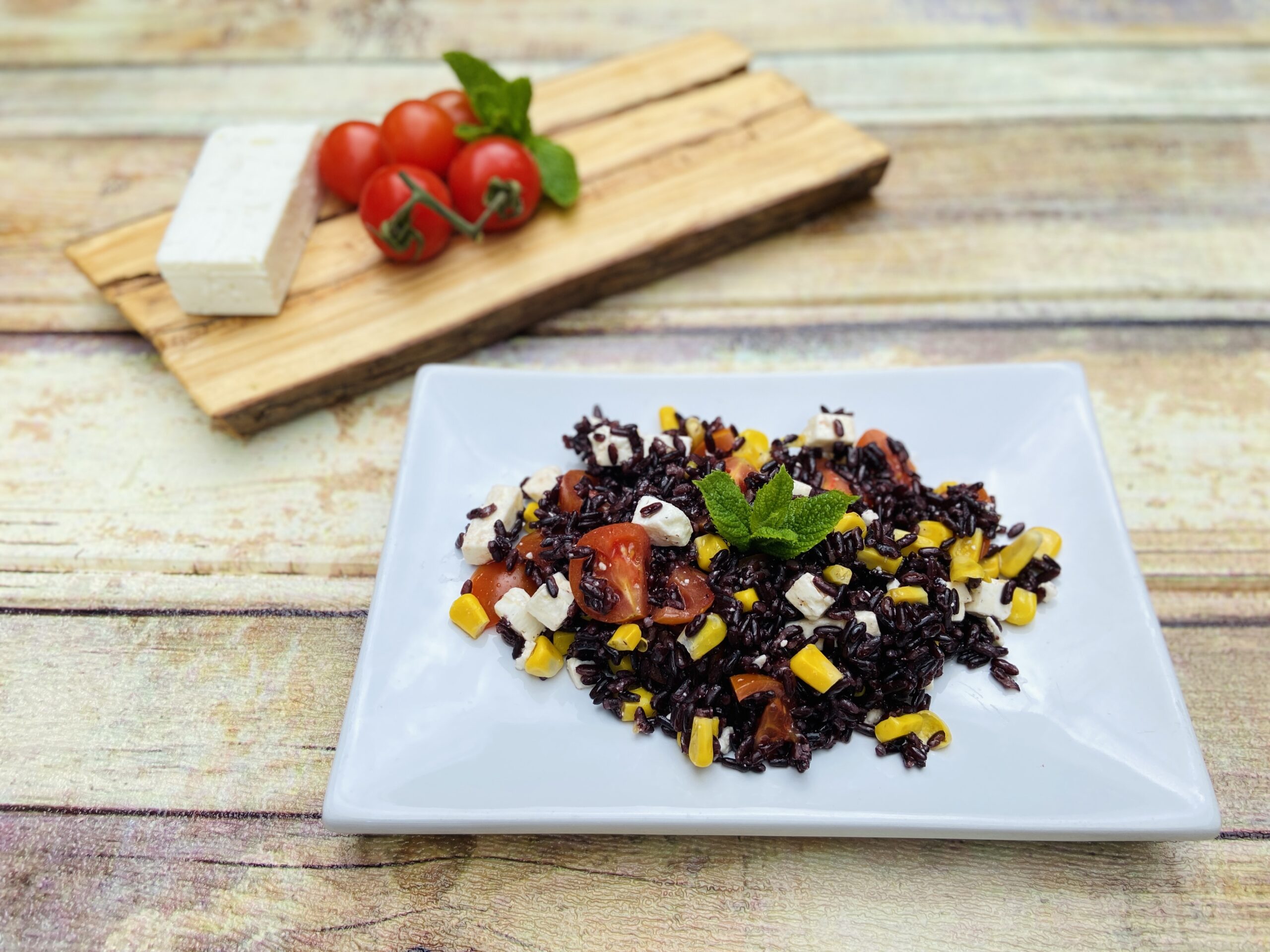 Arroz venere con feta maíz y tomatitos