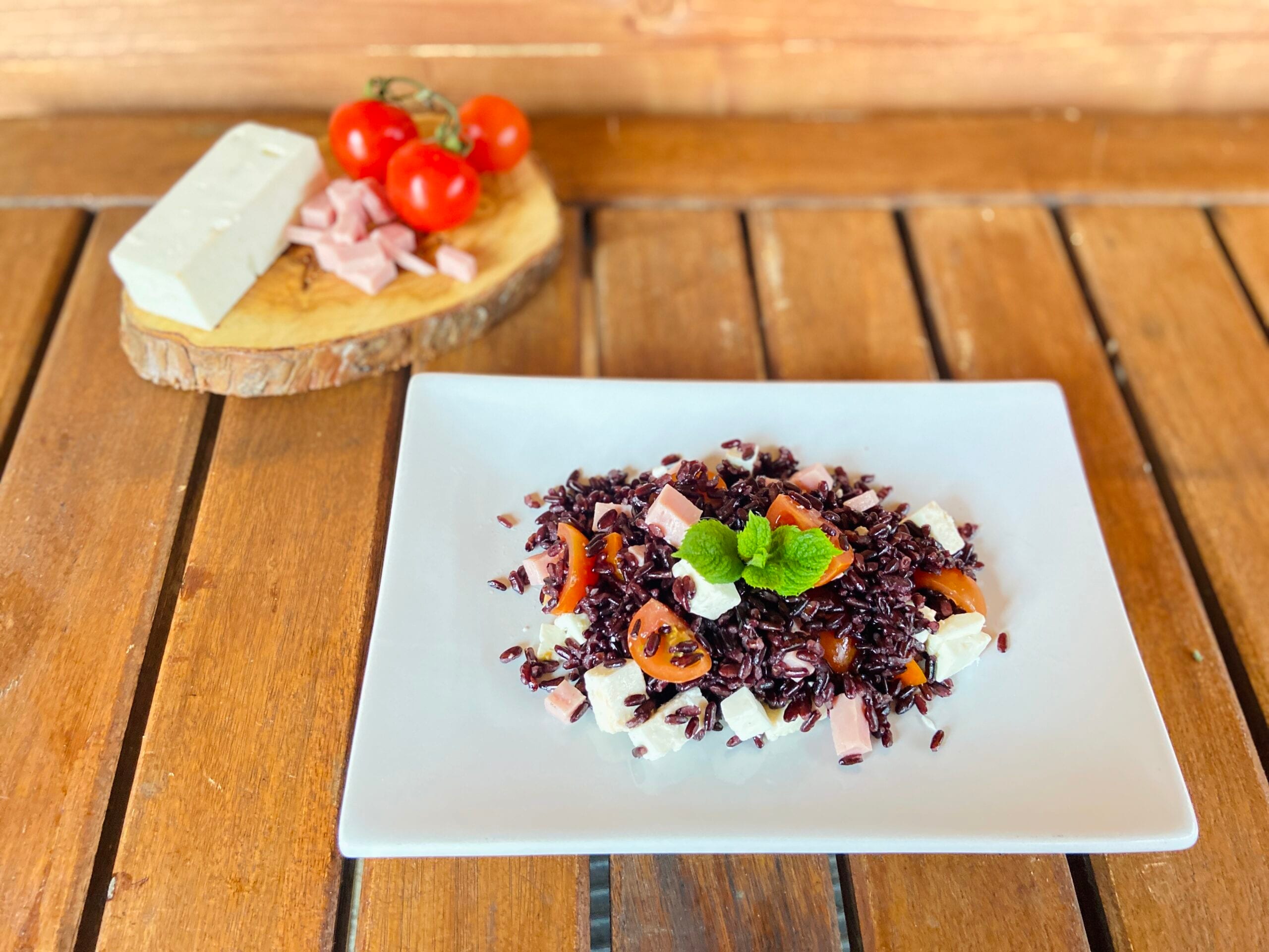 Arroz venere con feta, jamón y tomates cherry
