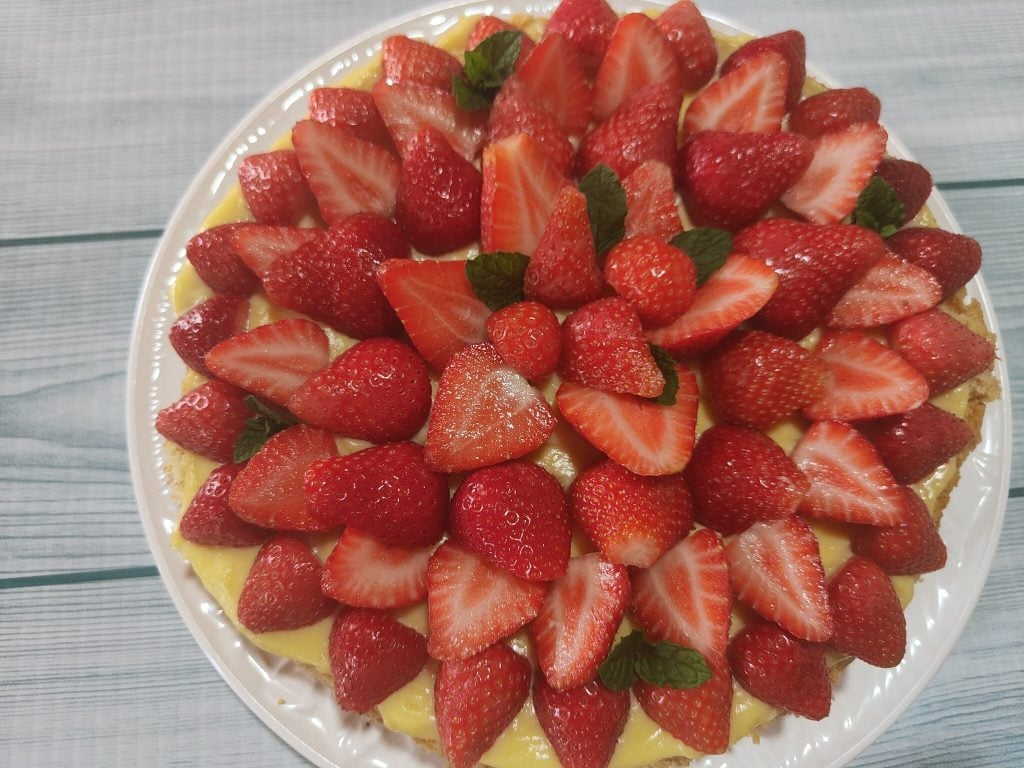 La tarta lista con crema y fresas