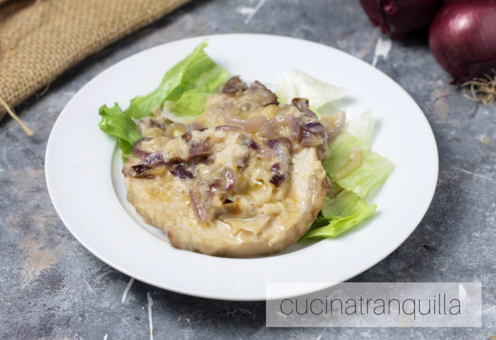 Bistec de cerdo con cebollas rojas