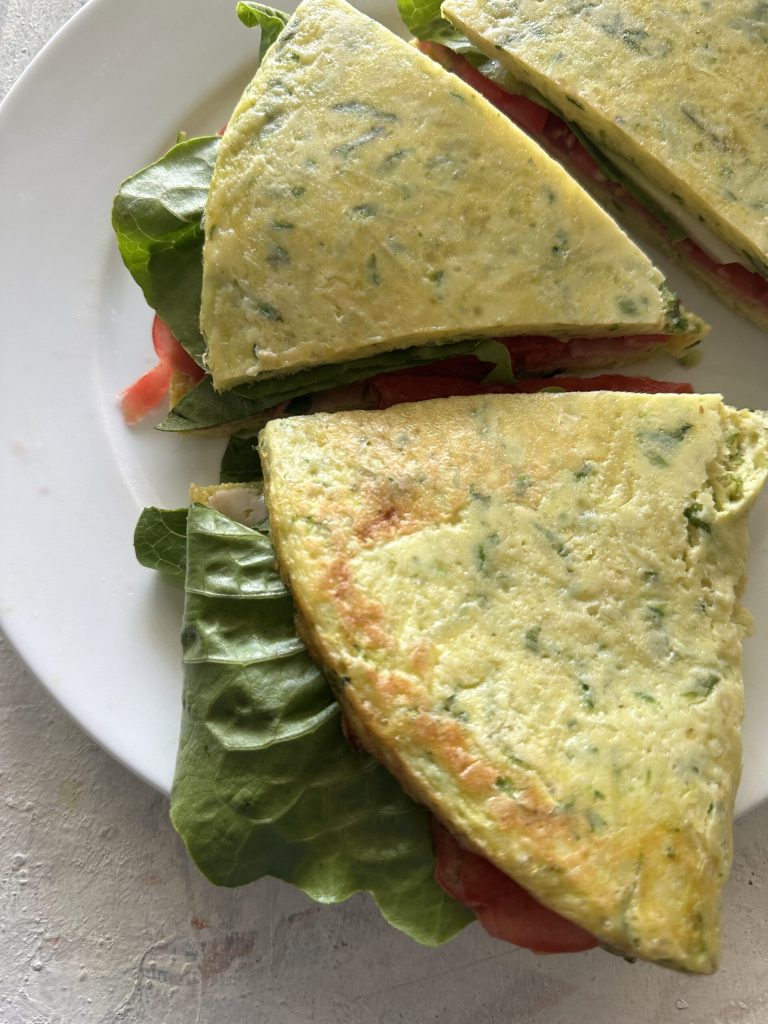 porciones de pancake de calabacín cocidos en el microondas rellenos con jamón, tomate y lechuga