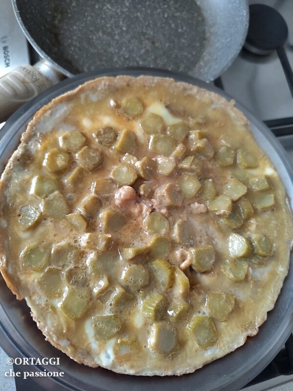 Cuando el lado en cocción esté listo, deslizar la tortilla sobre una tapa o un plato llano para girarla con facilidad.