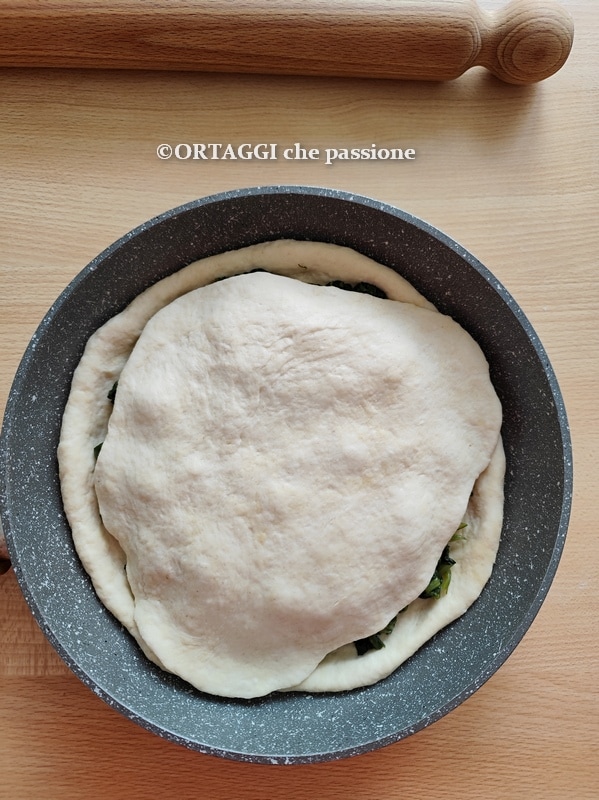 poner la masa sobre la focaccia en sartén con verduras