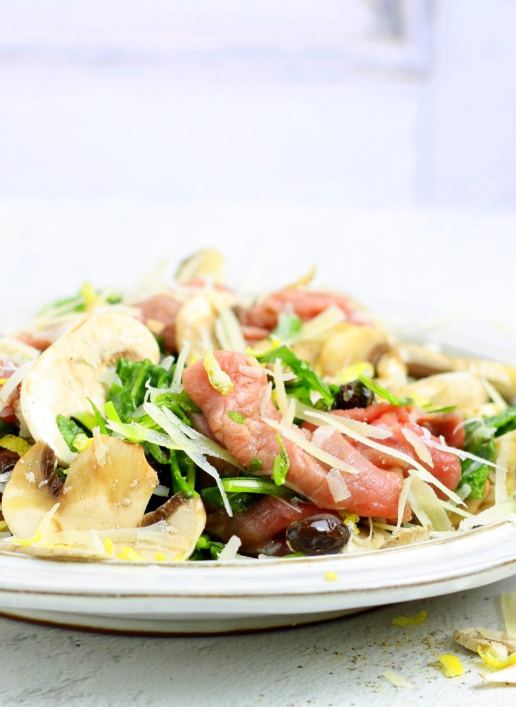 Carpaccio de ternera con champiñones, rúcula y aceitunas