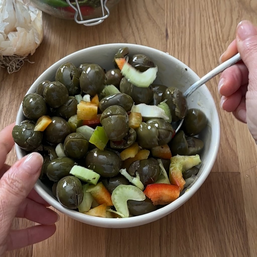 aceitunas verdes machacadas y sazonadas con apio y pimiento receta calabresa