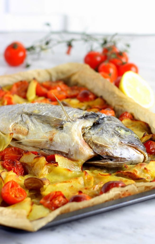 Dorada al horno con patatas, tomates cherry y ajo