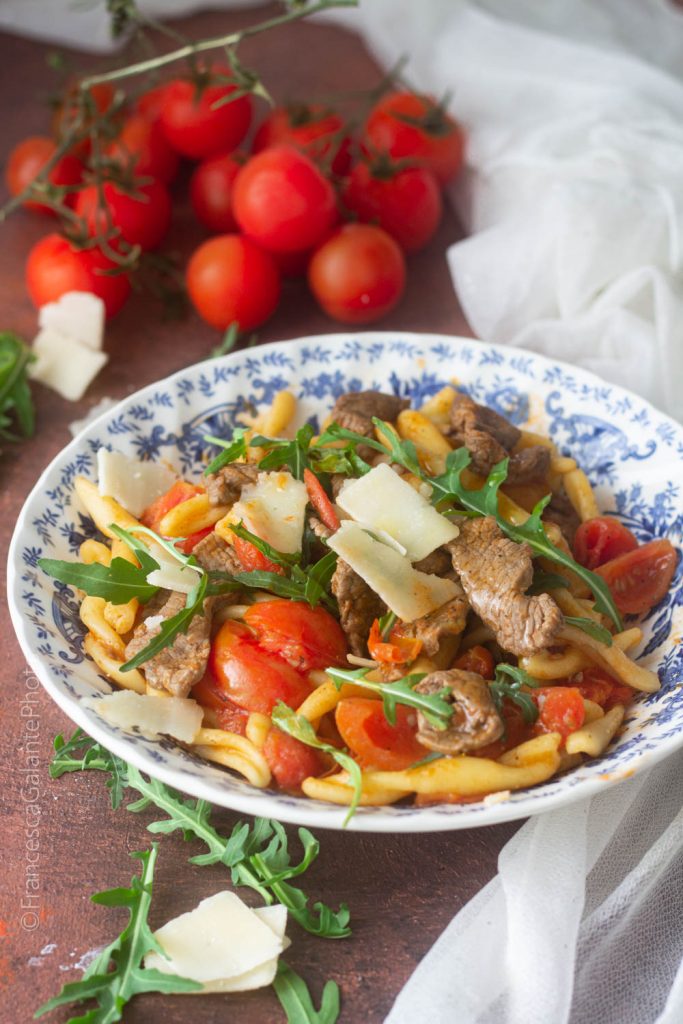 Pasta fresca con tiras de carne, tomatitos, rúcula y grana
