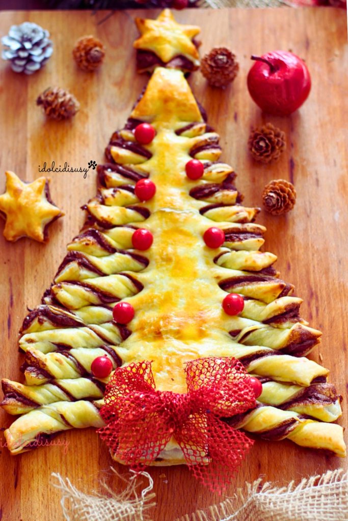Detalle del árbol de Navidad de hojaldre con decoraciones navideñas y lazo rojo