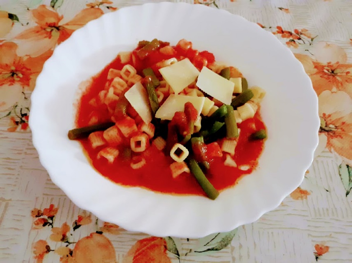 Pasta fría con judías verdes y tomate con virutas de queso