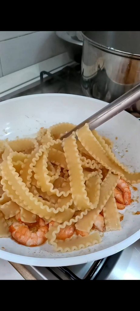 Saltear la pasta con los langostinos