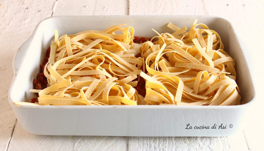 Nidi de tagliatelle gratinados con salchicha