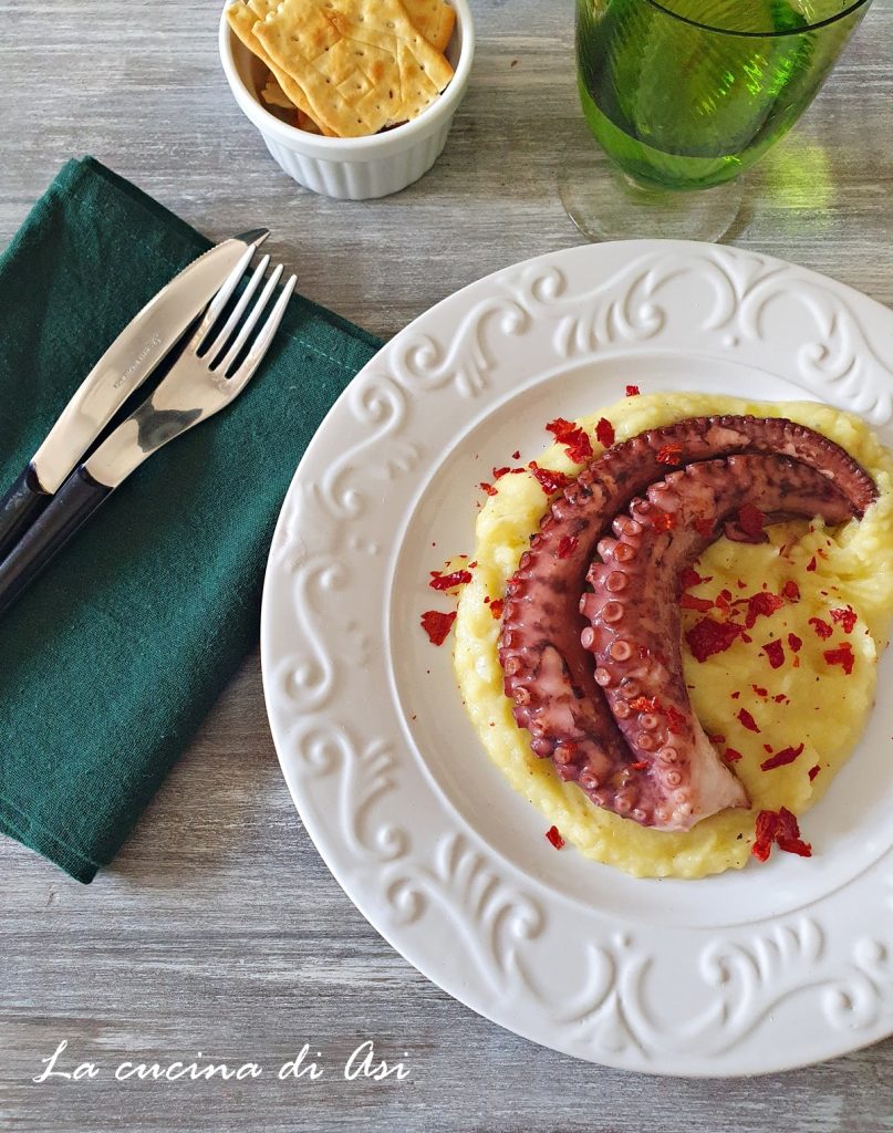 Pulpo crujiente servido sobre puré de patatas y pimientos secos desmenuzados – segundo plato elegante y fácil, perfecto también para la mesa de las fiestas.