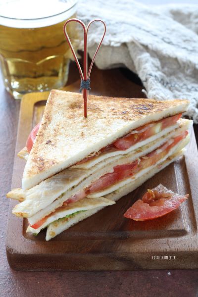 tagliate il sandwich per obliquo e servite con patatine e salse a piacere