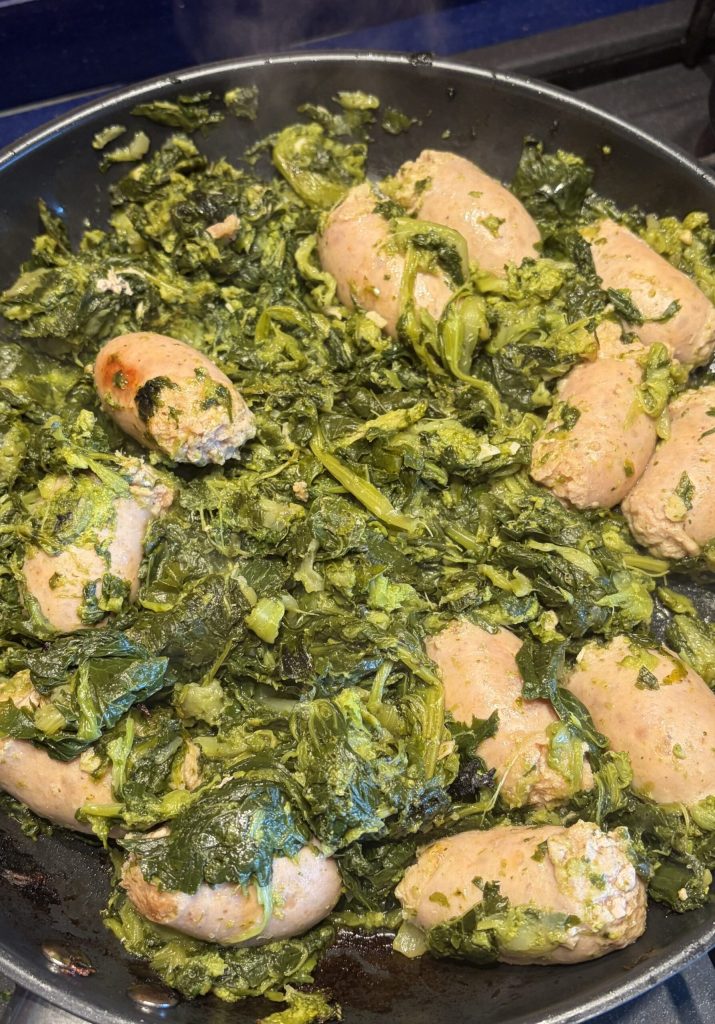 Salchicha en trozos dorándose en sartén con brócoli salteado a la romana durante la cocción