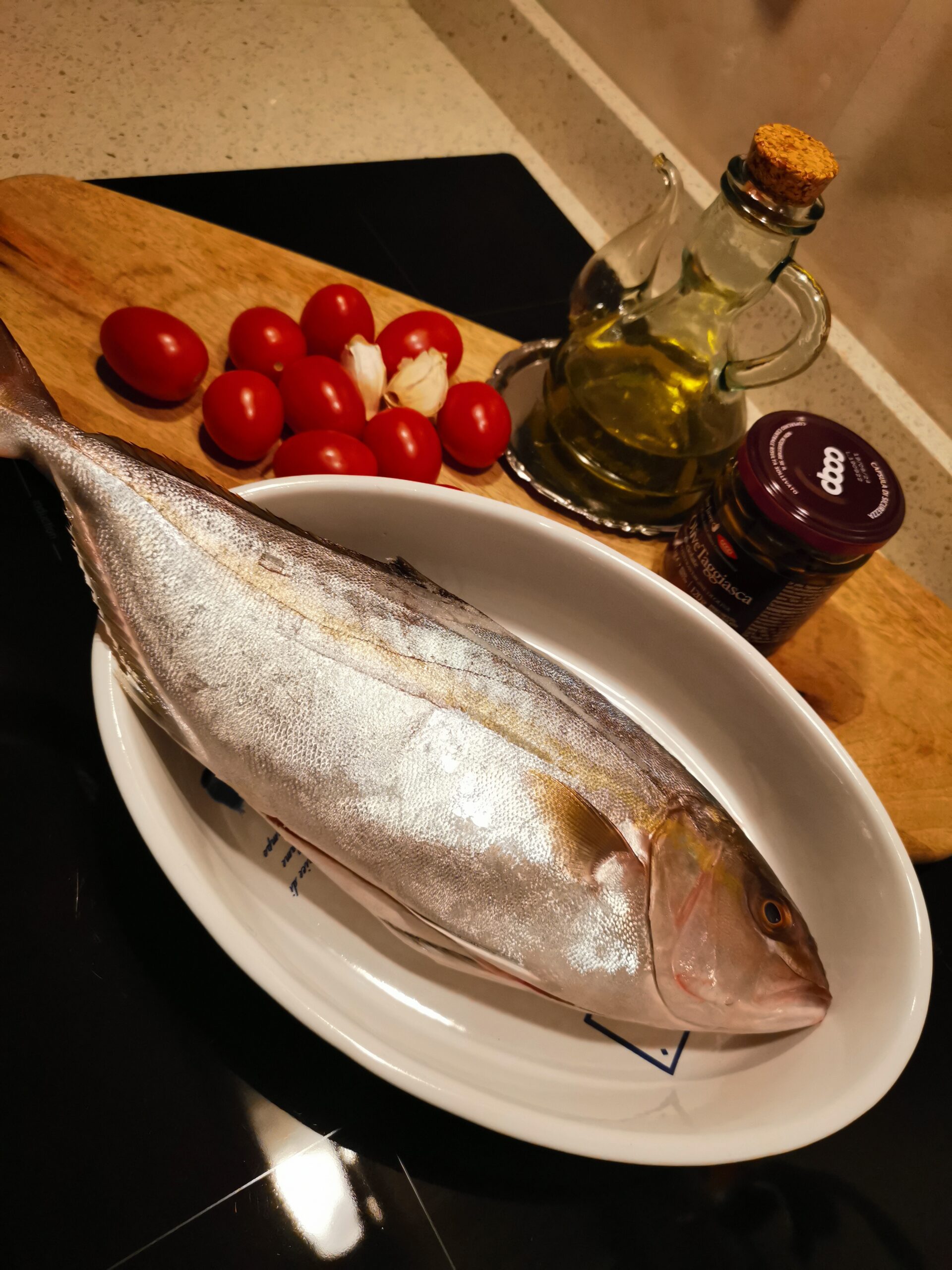 Serviola de pesca, con tomatitos, alcaparras y aceitunas taggiasche