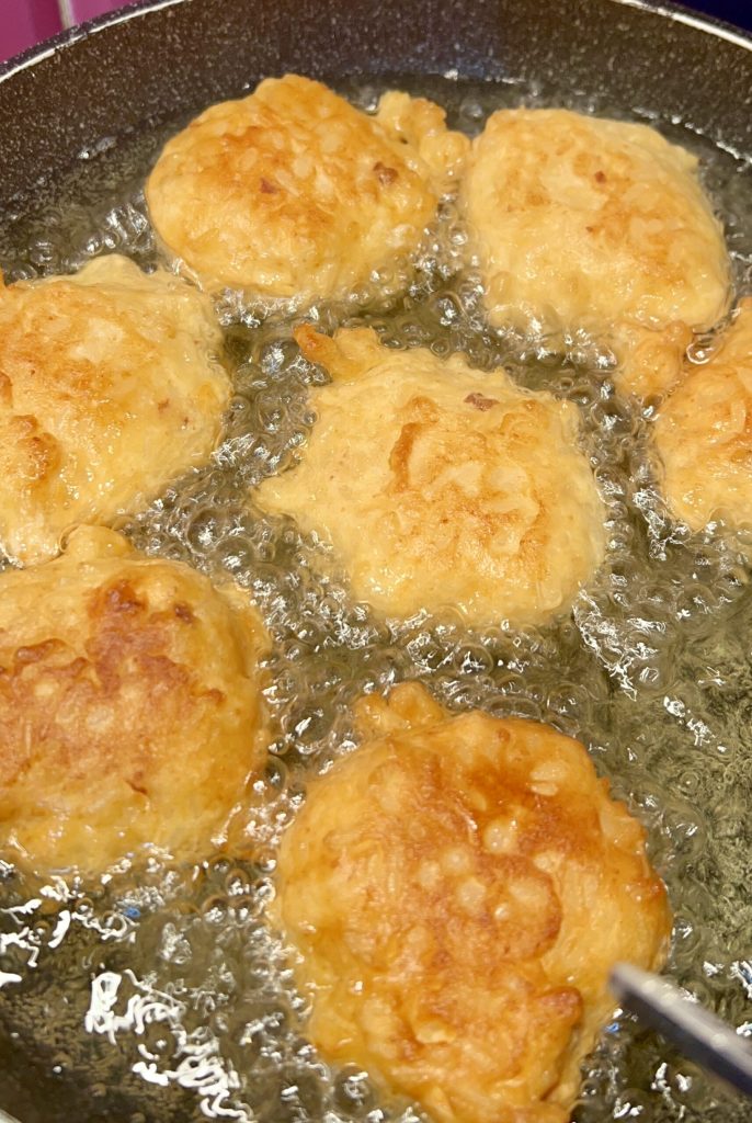 Buñuelos de arroz toscanos friendo en aceite caliente