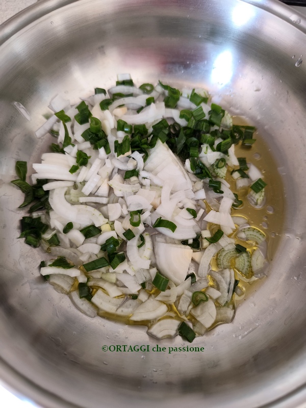 sofriendo la cebolla tierna blanca con tallos verdes