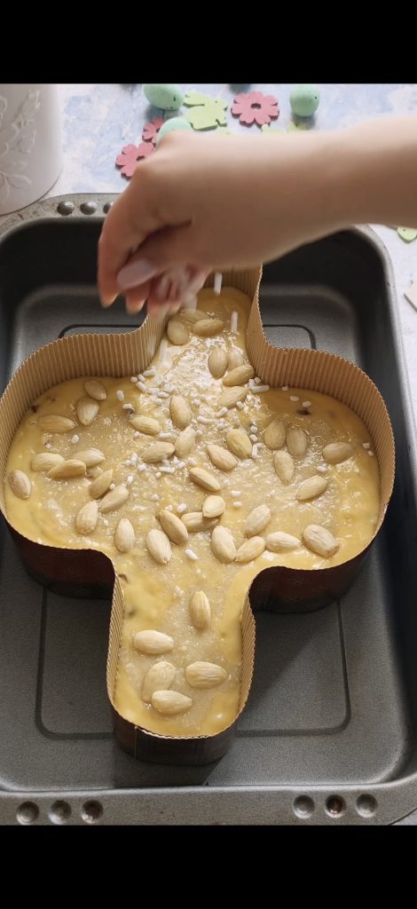 Distribuimos la cobertura, almendras y granillo de azúcar sobre la colomba