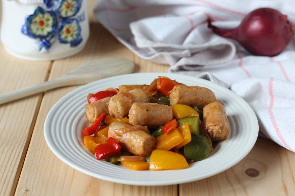 salchichas de pollo con pimientos y cebolla en sartén