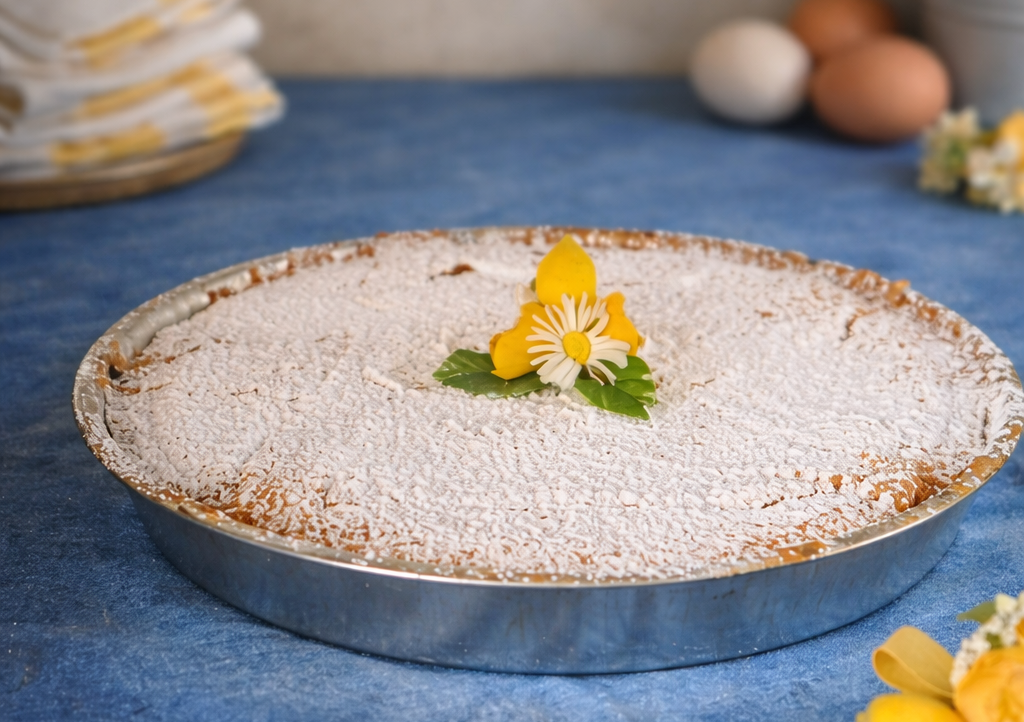 Pastiera decorada con azúcar glas sobre mesa de cocina