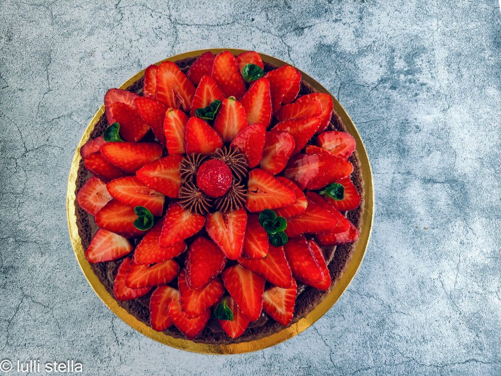 Postre de cacao sin gluten con crema suave y fresas frescas sobre una base esponjosa