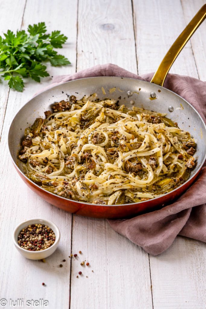 Pasta rústica con alcachofas y salchicha, detalle del condimento dorado y apetitoso