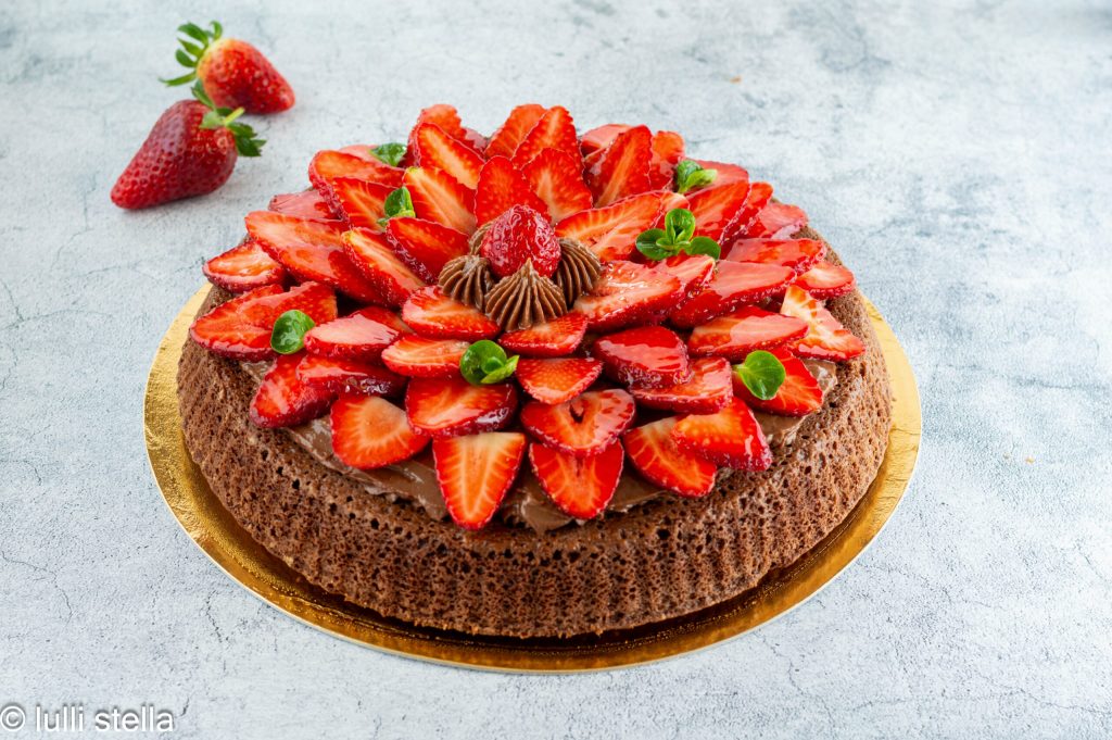 Tarta blanda de cacao con crema sedosa de chocolate y fresas frescas de primavera