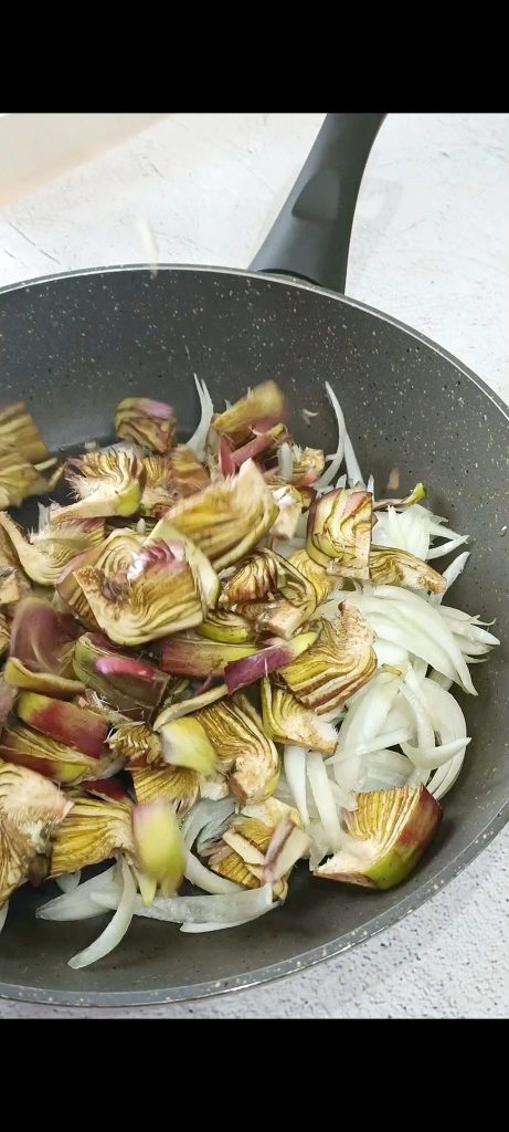 Cozinhamos as alcachofras na frigideira com óleo e cebola