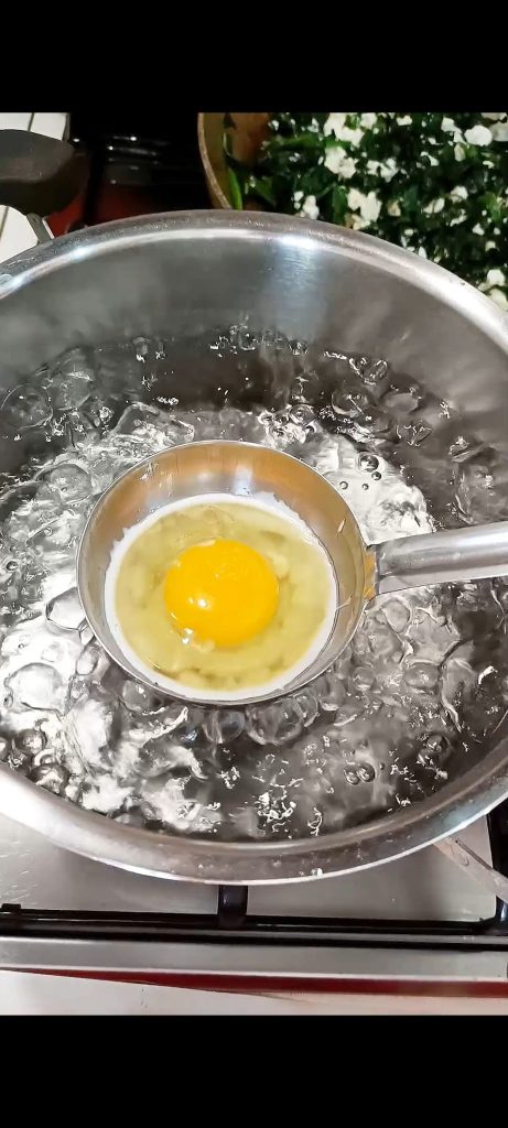 Ovo na concha em uma panela cheia de água fervente