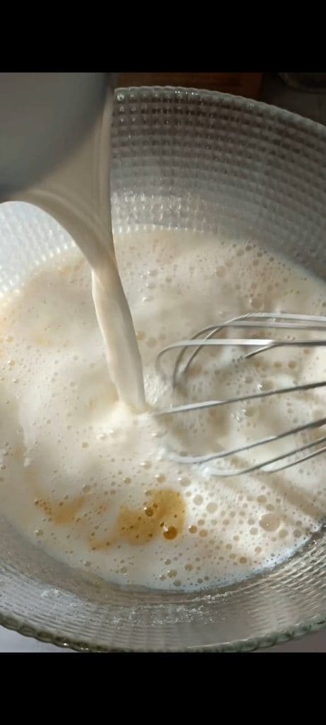 Despeje o leite quente sobre a mistura de ovos