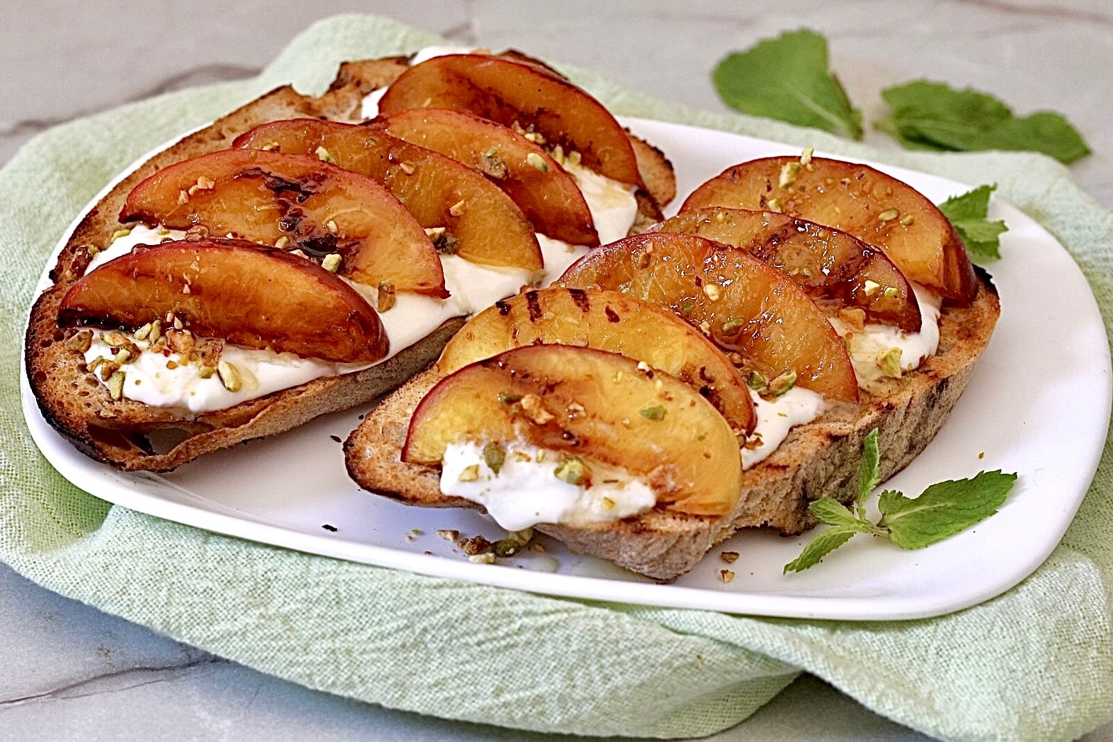 Bruschettas com pêssegos grelhados e stracciatella.